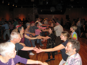 Callers direct contra dancers in a variety of dance configurations.