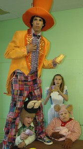 The Mad Hatter (Matthew Paessler), standing, and Alice (Annie Carr), background right, with the March Hare (Bradley Powers) and the Dormouse (Landon Camper) star in a scene from Theatre Bristol's "Alice in Wonderland."