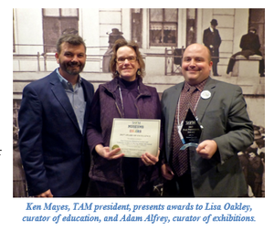 Ken Mays, TAM president, presents awards to Lisa Oakley, curator of education, and Adam Afrey, curator of exhibitions. 