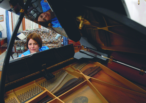 Evelyn Pursley-Kopitzke is working and reflected in the piano. (Photo by T. Duncan, Johnson City Press)