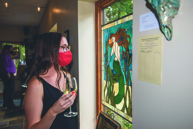 Visitors enjoy a class of wine and an art show. (photo by David Grace)