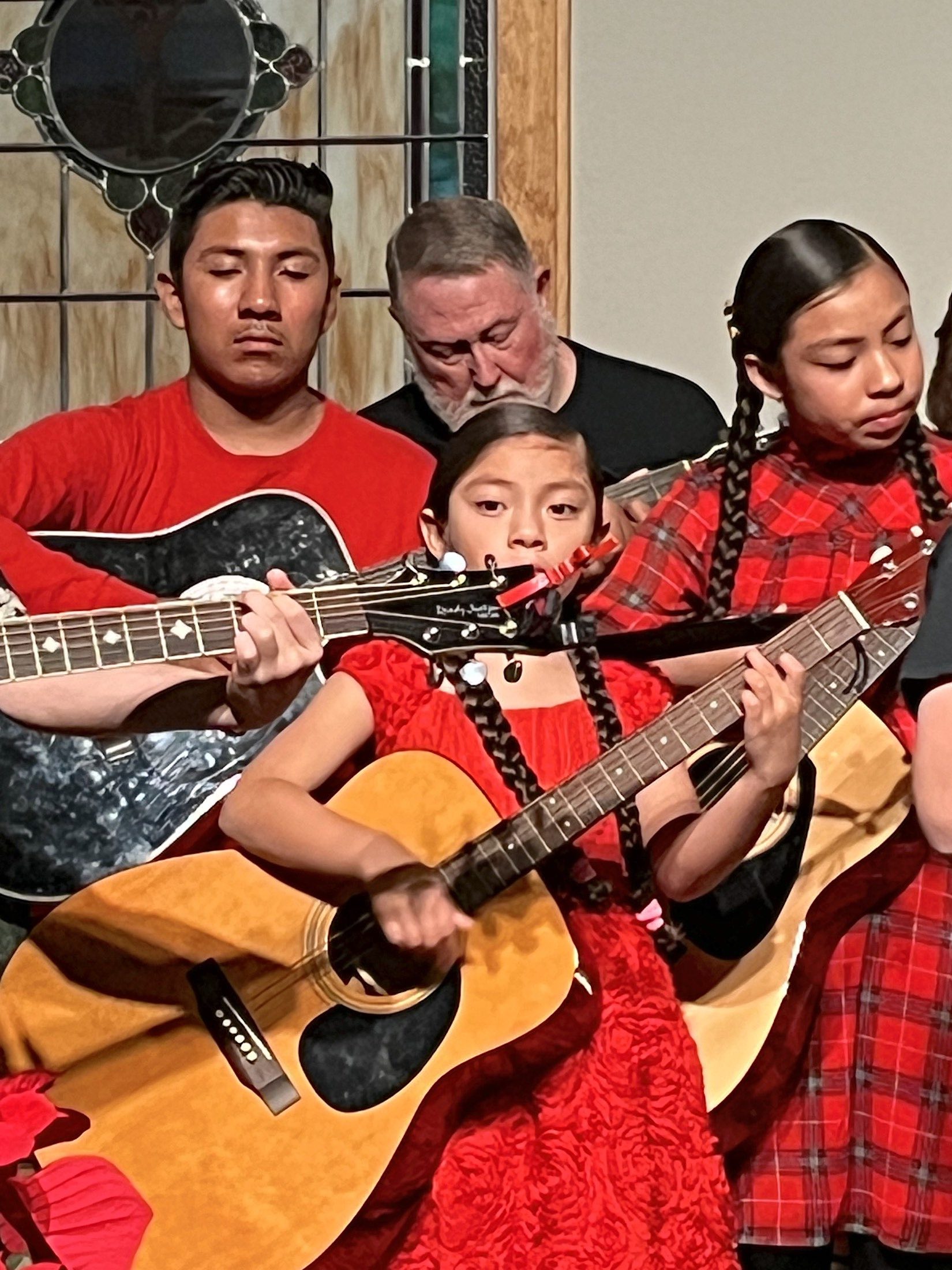JAM participants Immanuel, Sarai, and Adela Mendoza perform with instructor Russell Love (rear) duri
