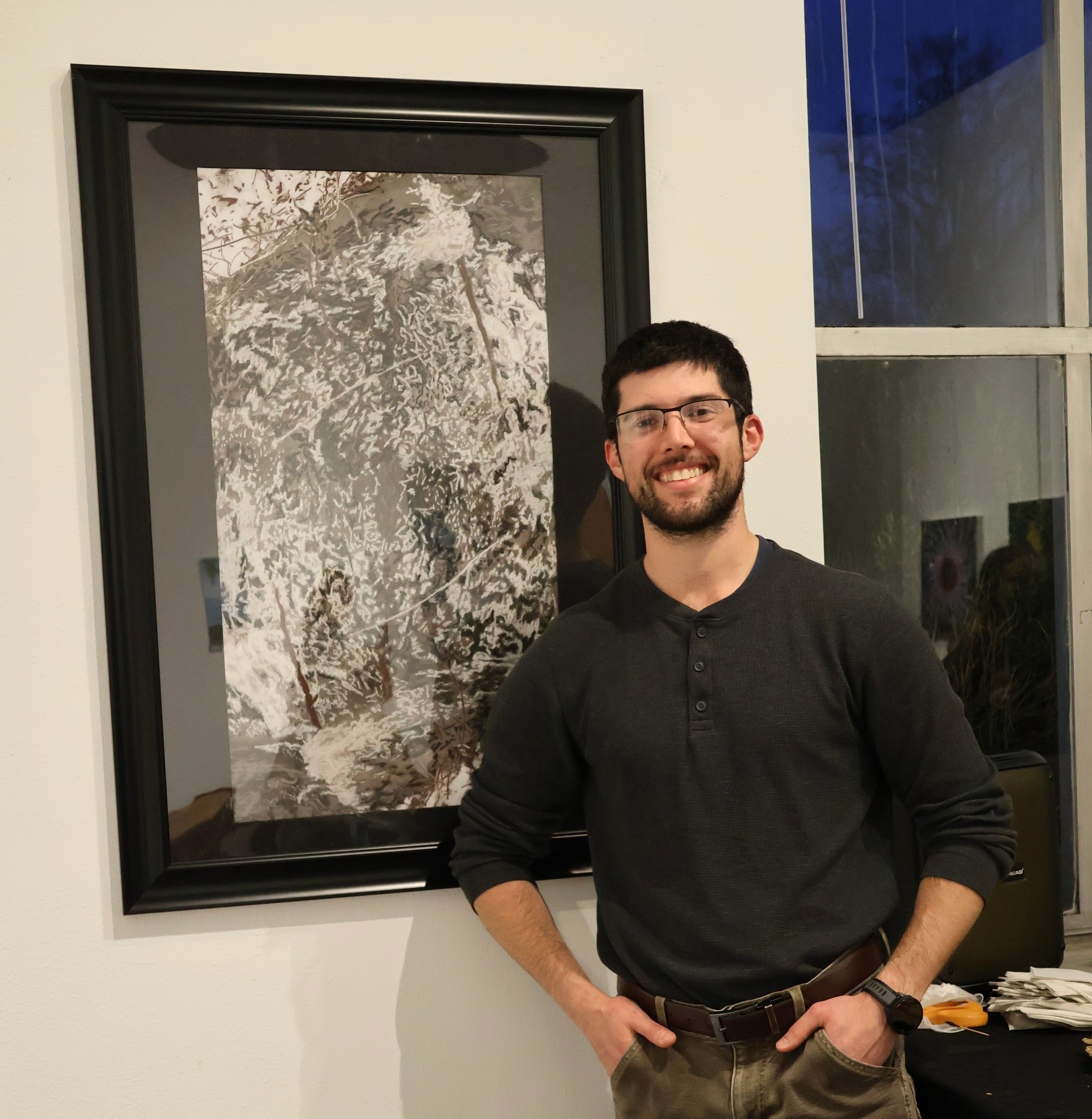 Benjamin Conley, assistant professor of art and design, presents a piece of his art that appears in the exhibit.